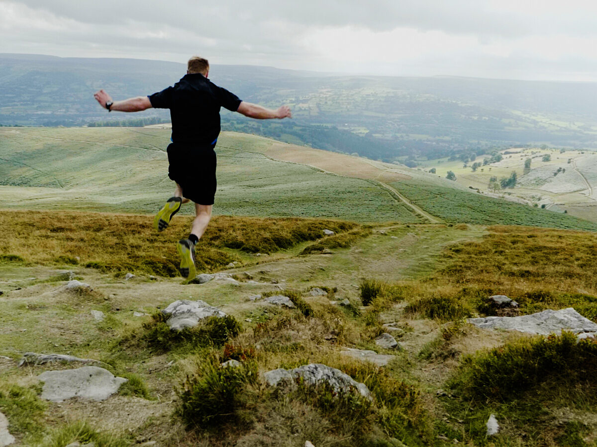 A man jumps on the top of the Sugarloaf Mountain on a cloudy and foggy day.